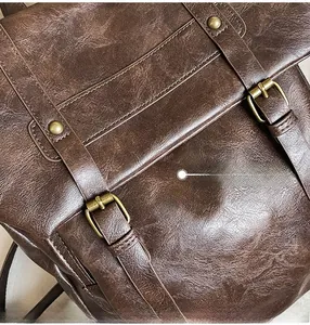 Detail of dark brown vintage leather texture and antique bronze metal buckle on the backpack