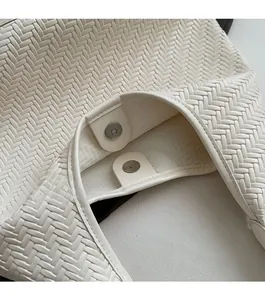 Close-up of the magnetic closure and woven texture on a white shoulder bag