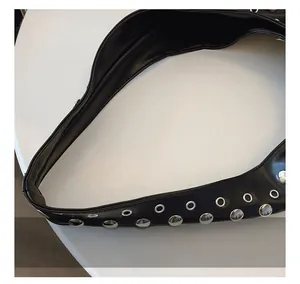 Vue détaillée de la bandoulière en cuir noir avec clous et œillets en métal argenté