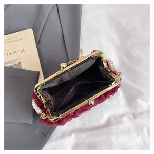 Close-up of wine red lace evening bag interior with dark fabric lining and pocket