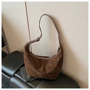 Gros plan détaillé du sac hobo en daim marron foncé avec coutures et fermeture éclair argent