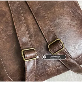 Detail of adjustable shoulder strap on vintage brown faux leather backpack with bronze buckle