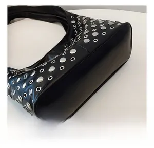 Gros plan détaillé du sac seau punk noir orné de rivets argentés et d'oeillets en métal