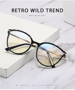 Detail view of anti-blue light glasses with retro round frame and gold metal temples