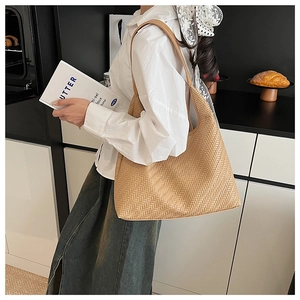 Detailed view of light brown woven tote bag showcasing premium faux leather texture