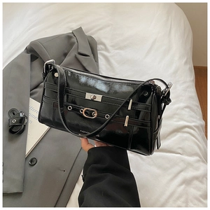 Detail der schwarzen Lackleder-Schultertasche mit silbernen Schnallen und Glanz