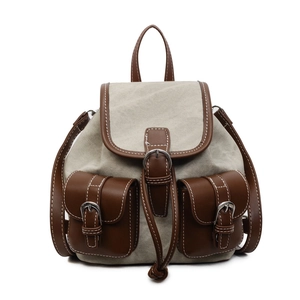 Vintage canvas and brown leather backpack with contrast stitching and buckle details