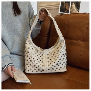 Détail du sac hobo beige avec rivets argentés et œillets en cuir PU souple et chic