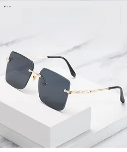 Détails des branches en métal doré ajouré et verres gris sur lunettes sans monture
