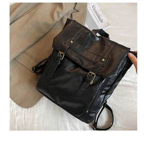 Detailed view of black vintage faux leather backpack with metallic buckles and side zipper
