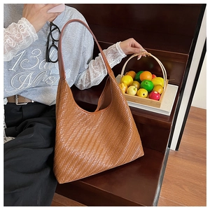 Detailed view of brown woven leather texture on a retro hobo shoulder tote bag
