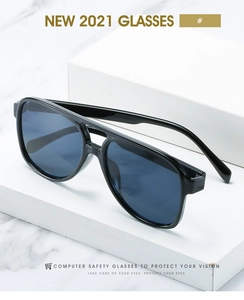 Detail view of double-bridge aviator glasses with glossy black frame on marble base
