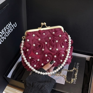 Elegant wine red evening bag featuring 3D fabric roses, pearls, and a golden metal clasp