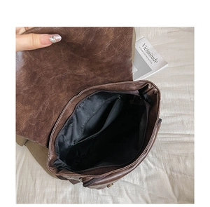 Detailed interior of vintage brown leather backpack showing zipped inner pocket