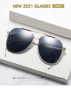 Vue détaillée de lunettes aviateur avec monture dorée et pont double élégant.