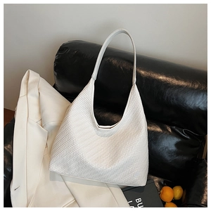 Detailed close-up of white woven leather hobo bag texture and elegant V-shaped pattern