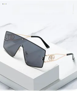 Detail of oversized square sunglasses with gold metal temples and double ring ornament