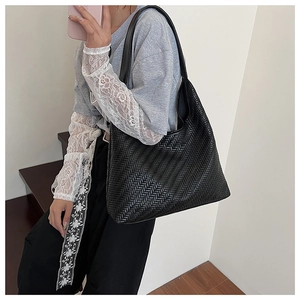 Detail of classic black woven pattern and premium faux leather texture on hobo bag