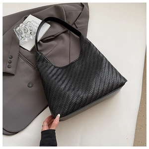 Close-up of black woven leather texture and hobo bag strap metal hardware