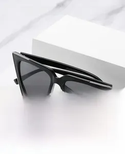 Détail de lunettes œil-de-chat noires avec accents argentés et verres protecteurs