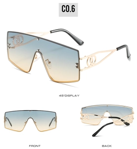 Detail of oversized shield sunglasses with blue-orange gradient lenses and hollow gold temples