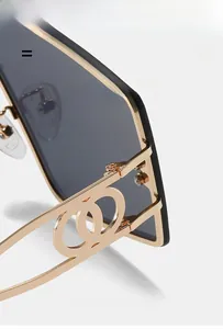 Detailed close-up of golden hollow double-ring logo design on square sunglasses temple