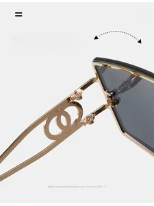 Detail of gold metal hinge with interlocking ring design on oversized square sunglasses