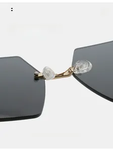 Detail shot of golden metal nose bridge and comfortable silicone pads on rimless sunglasses