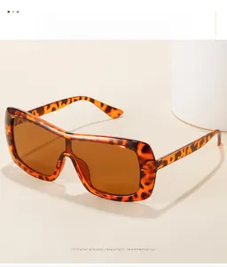 Detail shot of large tortoiseshell sunglasses with brown lenses on a white pedestal