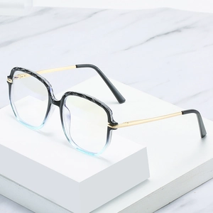Blue gradient TR90 cat-eye glasses with gold metal arms on white marble display
