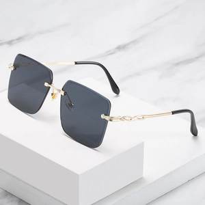 Lunettes de soleil carrées sans monture avec branches dorées ondulées et verres gris