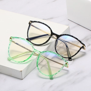 TR90 round blue light blocking glasses with gold metal temples on white marble display