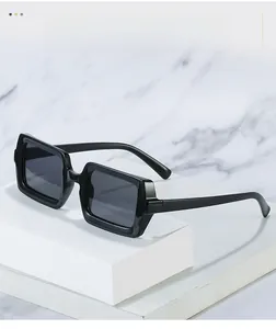 Detailed texture view of black rectangular chunky frame sunglasses on marble surface