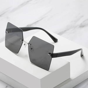 Fashionable rimless square sunglasses with grey lenses on white geometric display
