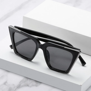 Lunettes de soleil œil-de-chat noires avec bordure argentée sur présentoir chic