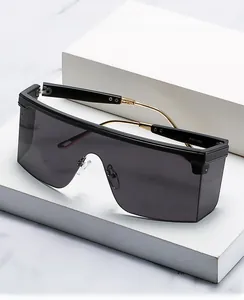 Detailed side view of oversized sunglasses featuring gold metal temples and black frame