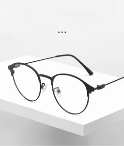 Gros plan d'une monture de lunettes ronde en métal noir mat sur un socle minimaliste