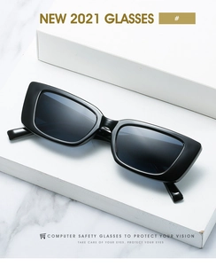 Close-up of black rectangular sunglasses on marble steps with light reflection