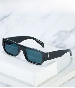Detail of black rectangular sunglasses with dark blue lenses on marble background