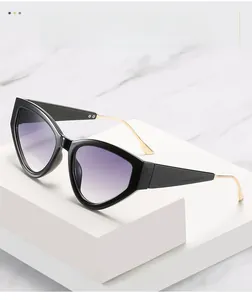 Detail of black cat-eye sunglasses with purple gradient lenses on a white marble stand