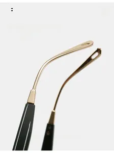 Detailed macro view of gold metal sunglasses legs with ergonomic curved black tips