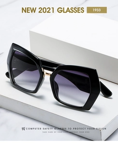 Detail of oversized geometric sunglasses with purple gradient lenses on marble background