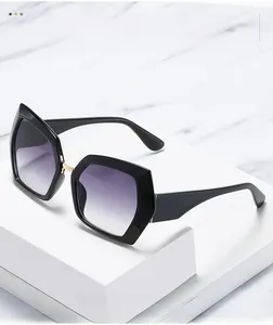Detailed view of hexagonal black frame sunglasses with purple gradient lenses on marble