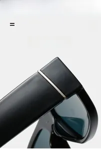 Detail of black sunglasses hinge with silver metal trim and polished texture