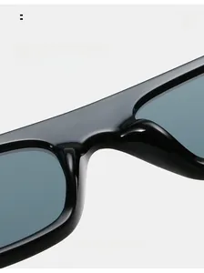 Detail of high-gloss black square sunglasses featuring comfortable integrated nose pads