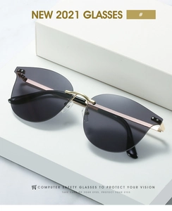 Close-up of rimless grey sunglasses with gold metal temples and computer safety lenses