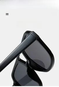 Detail of black square resin sunglasses showing durable hinges and polished texture