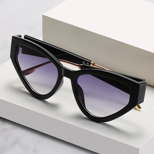 Modern cat eye sunglasses with thick black frames and purple gradient lenses on display