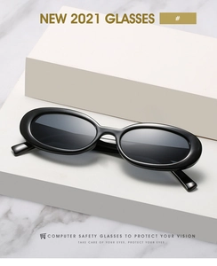Détail de lunettes de soleil ovales noires sur des supports blancs et fond de marbre