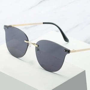 Modern rimless oversized cat eye sunglasses with gold metal temples and dark grey lenses